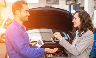 image of a woman giving keys to a mechanic